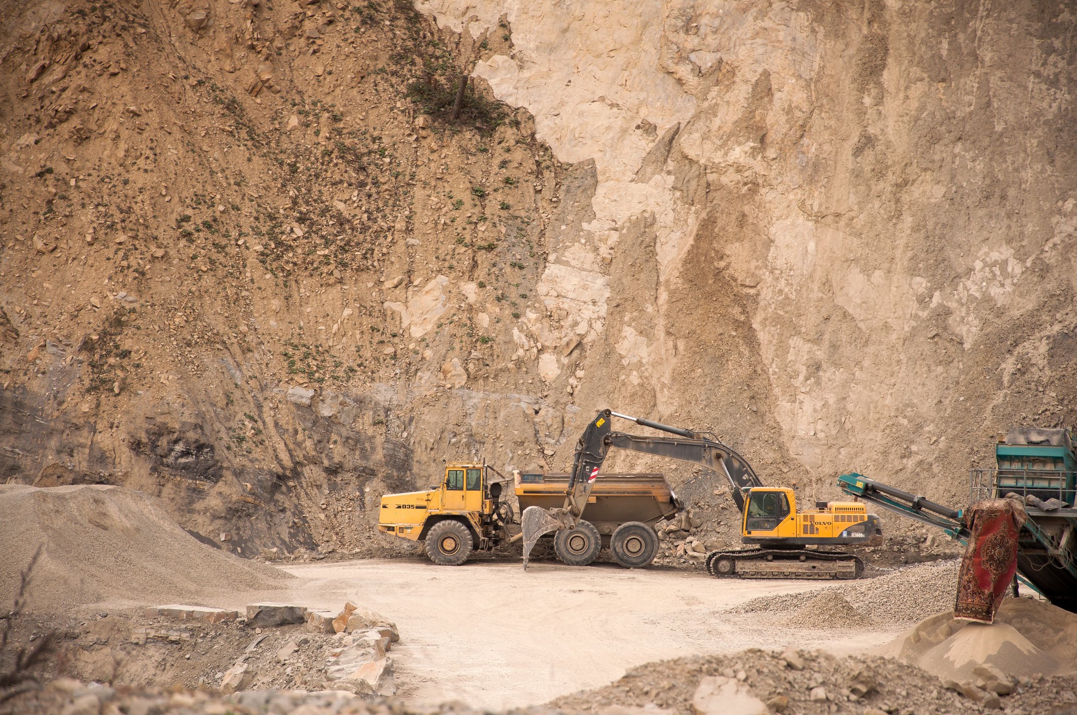 Excavator near industrial machines in quarry